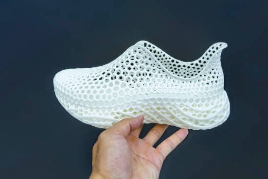 hand with 3d printed shoe figure close-up