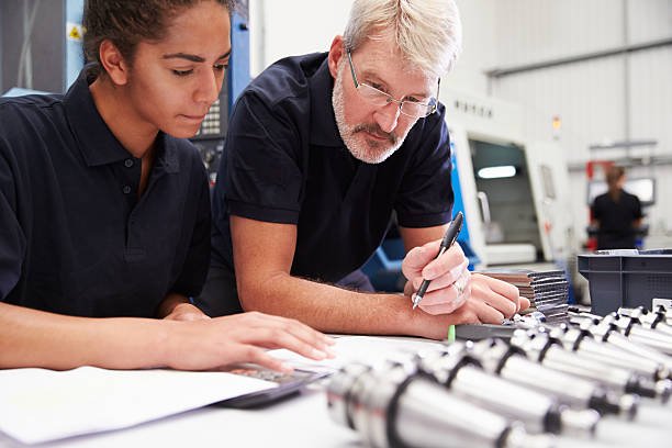 Engineer And Apprentice Planning CNC Machinery Project